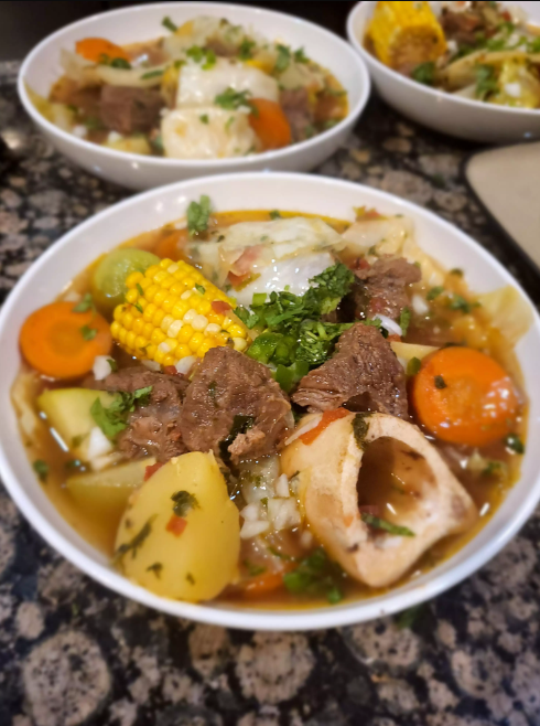 Steaming bowl of Caldo de Res with vibrant vegetables and tender beef"