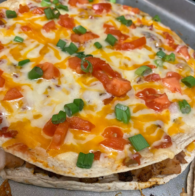 Delicious homemade Mexican pizza loaded with refried beans, cheese, and fresh toppings on a crispy tortilla crust.