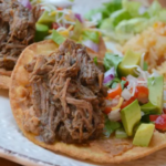 Savory shredded beef recipe served with tortillas and fresh vegetables.