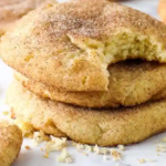 Freshly baked snickerdoodle cookies without cream of tartar arranged on a rustic wooden table.