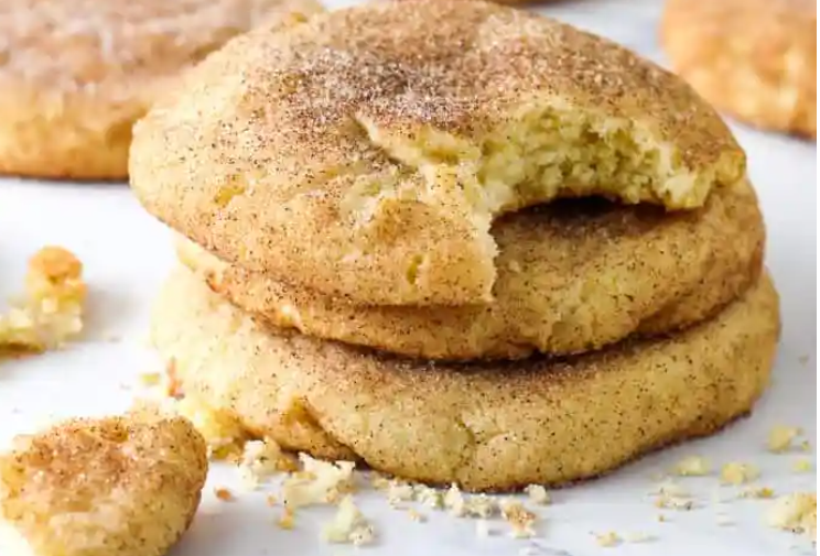 Freshly baked snickerdoodle cookies without cream of tartar arranged on a rustic wooden table.
