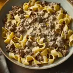 A delicious plate of Beef Stroganoff served over egg noodles with a creamy mushroom sauce.