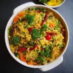 Alt text: A colorful one-pot spiced vegetable rice recipe featuring vibrant mixed vegetables, fluffy rice, and aromatic spices garnished with fresh herbs, all cooked together in a single pan.