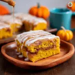 Alt text: "A moist and golden Pumpkin Honey Bun Cake topped with a sweet glaze, beautifully presented on a plate, showcasing the delicious result of the Pumpkin honey bun cake recipe."