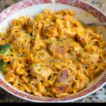 Alt text: "A delicious chicken pasta recipe featuring tender pieces of chicken, creamy cheese sauce, and perfectly cooked pasta garnished with fresh herbs in a rustic bowl."