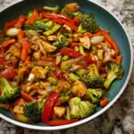 A colorful chicken vegetable stir fry recipe featuring tender chicken pieces, crisp bell peppers, bright broccoli florets, and vibrant carrots in a savory sauce, served over steamed white rice.