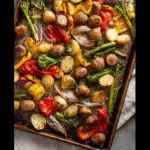 Alt text: "A colorful and delicious Italian chicken sausage and vegetables recipe featuring roasted chicken sausages, bell peppers, zucchini, and cherry tomatoes on a sheet pan."