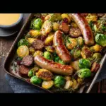 Alt text: "A delicious Honey Mustard Chicken Sausage Recipe featuring grilled chicken sausages drizzled with honey mustard sauce, served alongside roasted Brussels sprouts on a rustic wooden table."